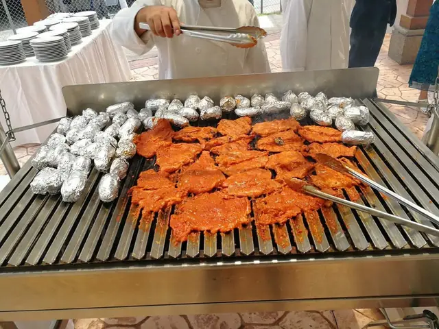 Carne adobada y papas en papel aluminio en la parrilla